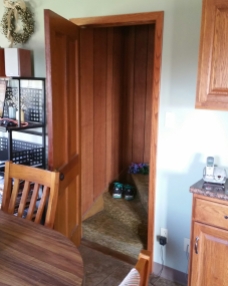 The doorway that leads from the downstairs kitchen to the bedrooms upstairs. It still has the same door, the same carpeting, and the same wood paneling from when I grew up there.